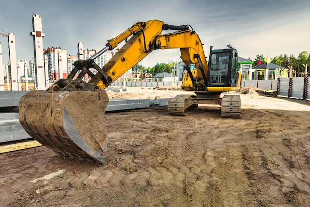 Una potente excavadora sobre orugas está trabajando en un sitio de construcción Primer plano Preparación de un pozo para la construcción Excavación