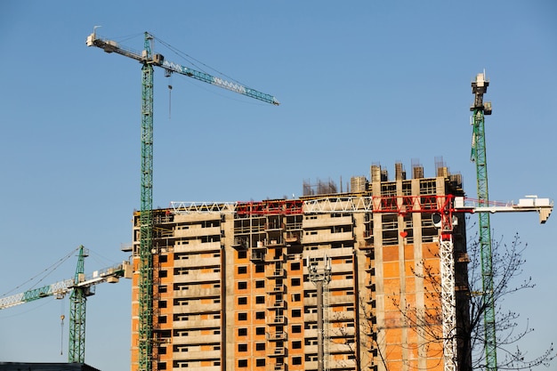 Potente grúa de gran altura en el fondo de un nuevo complejo residencial en construcción