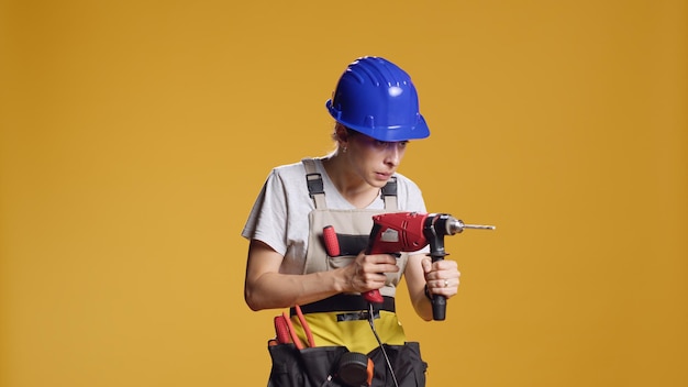 Foto potente manitas que usa una pistola de clavos de perforación eléctrica para atornillar clavos, trabajando con una máquina de pistola de perforación eléctrica en la reparación de la construcción. reconstrucción de arquitectura en proyecto de ingeniería en estudio.