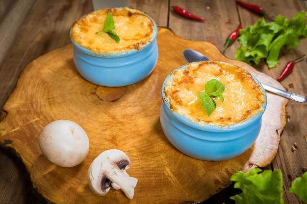 Potes con hongo julienne en una tabla de madera