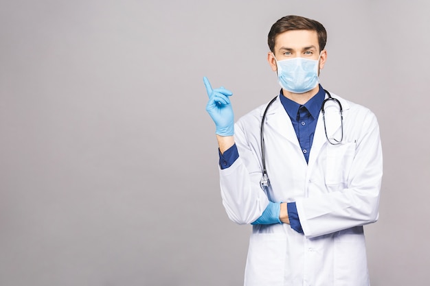 Potrait de guapo médico con máscara protectora quirúrgica y guantes azules