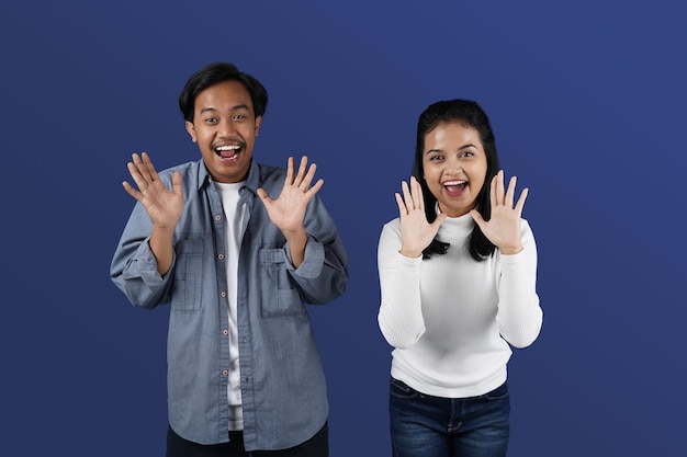 Potrait de pareja asiática posando con sus palmas mirando a la cámara con expresión sorprendida