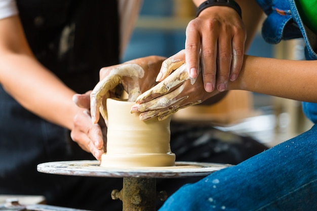 Potter creando un tazón de arcilla en la rueda giratoria.