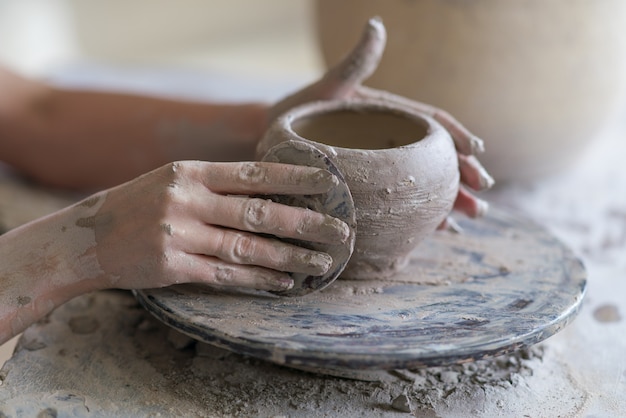 Potter esculpe um vaso na roda de oleiro