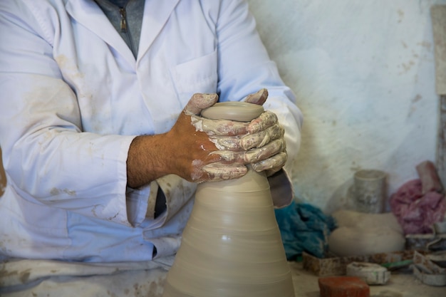 Potter haciendo jarrones de arcilla blanca