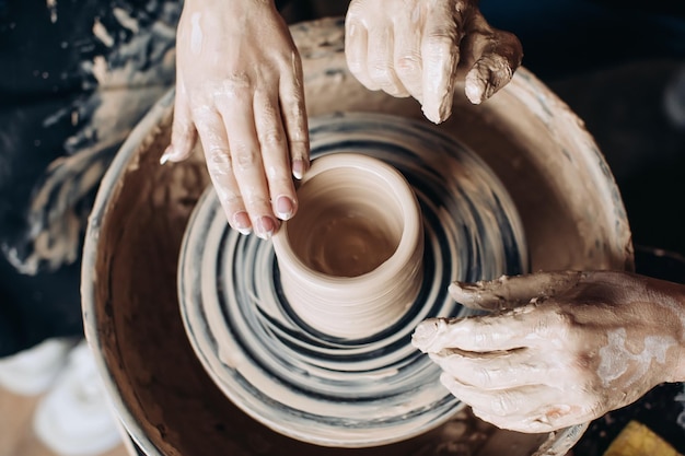 Potter macht einen Krug auf einer Töpferscheibe Handarbeit