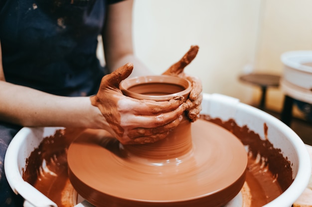 Potter en el proceso de crear un producto de arcilla