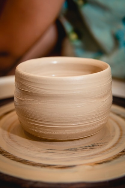 Potter trabalhando na roda de oleiro com argila. Processo de fabricação de louças de cerâmica na oficina de cerâmica. Conceito de artesanato e arte.