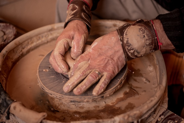 Potters Hände arbeiten mit Ton und machen es zu einem Produkt