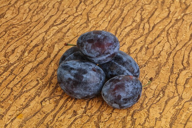 Poucas ameixas maduras sobre o fundo