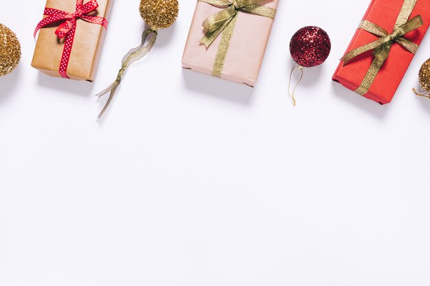 Poucas caixas de presente em papel de embrulho com fita e bolas de Natal