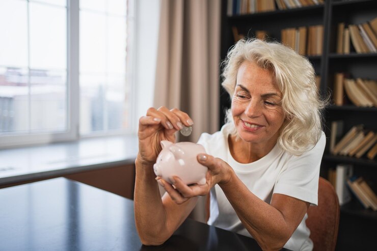 Foto poupando dinheiro investimento para o futuro idoso adulto mulher madura colocando moeda de dinheiro no coelho banco velho