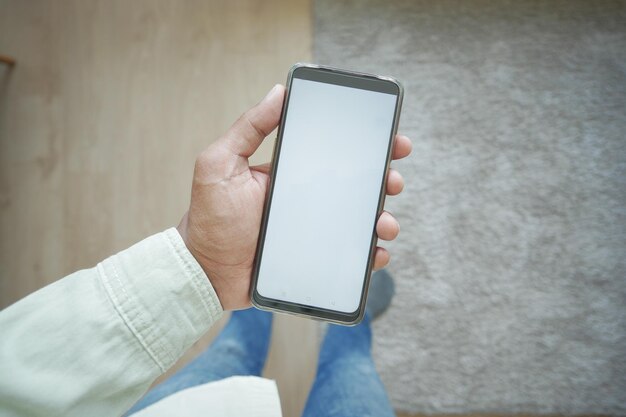 Foto pov-aufnahme eines smartphones mit weißem bildschirm zu hause