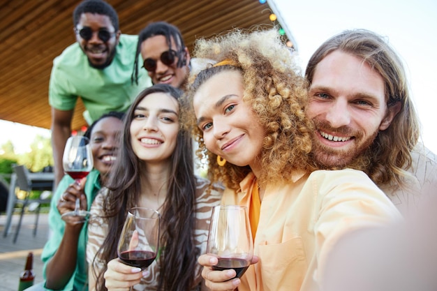 Pov-Aufnahme von Freunden, die während einer Outdoor-Party im Sommer ein Selfie-Foto machen und alle in die Kamera lächeln