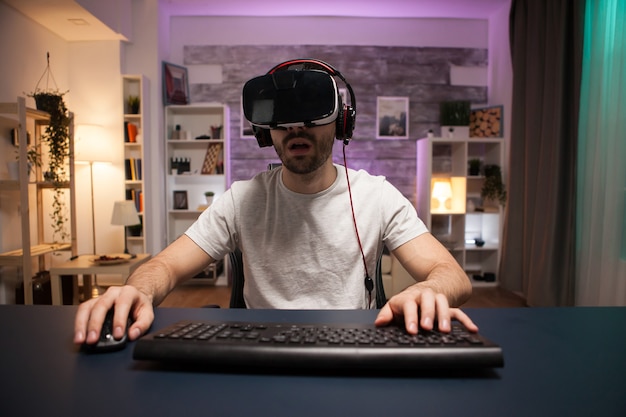 Pov de jogador online profissional concentrado usando um fone de ouvido de realidade virtual.