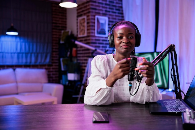 POV de mujer influyente creando contenido de podcast en estudio, grabando con cámara y equipo de sonido moderno. Vloguera filmando video y hablando con la audiencia para el canal de Internet.