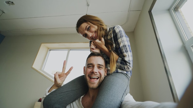 Foto pov de una pareja linda y amorosa hablando por video chat en línea sosteniendo un teléfono inteligente y charlando con amigos