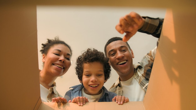 Pov ponto de vista dentro de caixa de papelão família afro-americana pais menino criança criança aberta