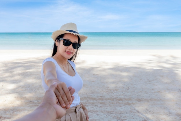 POV Sicht Folgen Sie mir Frau tragen Sonnenbrille führt Freund von Hand zum Meer