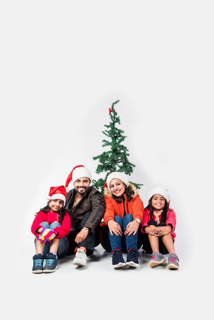 Povo índio celebrando o Natal com roupas quentes e árvore no fundo branco