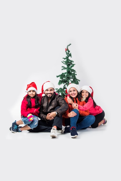 Povo índio celebrando o Natal com roupas quentes e árvore no fundo branco