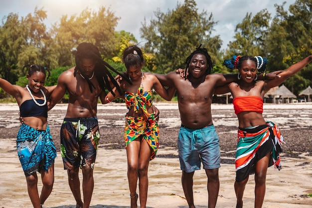 Povo queniano dança na praia com roupas típicas locais