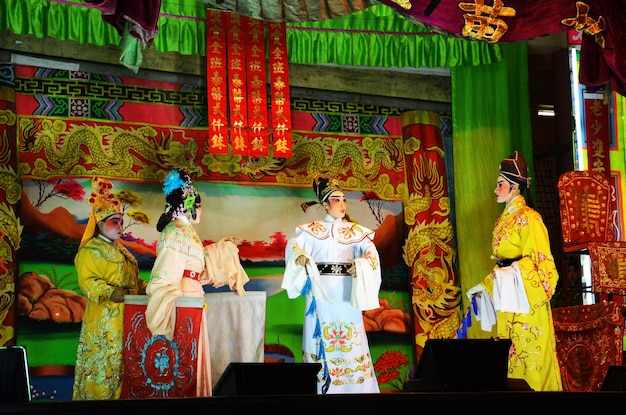 Povo tailandês de ascendência chinesa atuando tocando presente ópera clássica contemporânea chinesa tradicional para mostrar a população local no festival de feliz ano novo na cidade em 13 de março de 2011 em Bangkok Tailândia