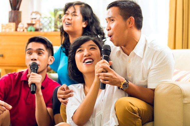 Povos asiáticos cantando na festa de karaokê e se divertindo