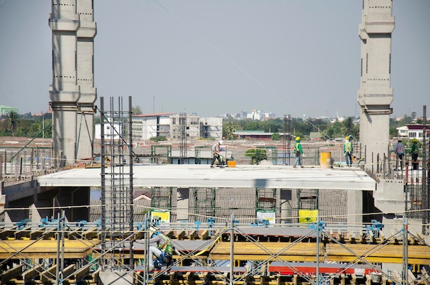 Povos asiáticos e trabalhadores tailandeses com construção de máquinas pesadas trabalhando novo edifício no canteiro de obras arranha-céus no andaime na capital em Bangkok Tailândia