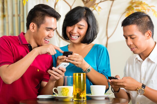 Povos asiáticos se divertindo com telefone celular