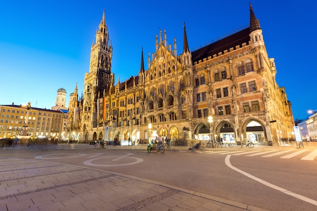 Povos que andam no quadrado de Marienplatz e na câmara municipal de Munich na noite em Munich, Alemanha.