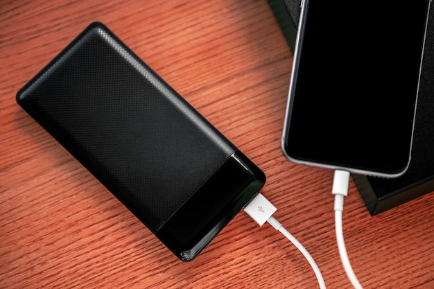 Powerbank carrega smartphone isolado em madeira