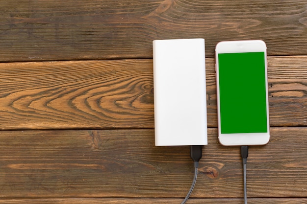 Powerbank y celular en mesa de madera