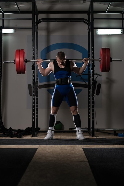 Powerlifter fazendo exercício para pernas com barra