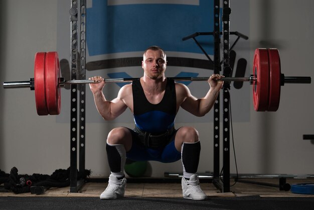 Powerlifter fazendo exercício para pernas com barra