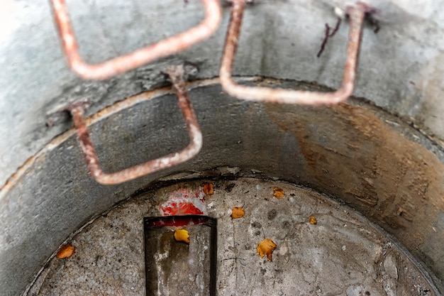 Un pozo hecho de anillos de hormigón armado con agua en el fondo. Dentro del pozo. Alcantarillado bien desde el interior.