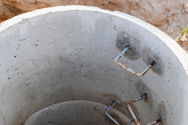 Un pozo hecho de anillos de hormigón armado con agua en el fondo Dentro del pozo Pozo de alcantarillado desde el interior