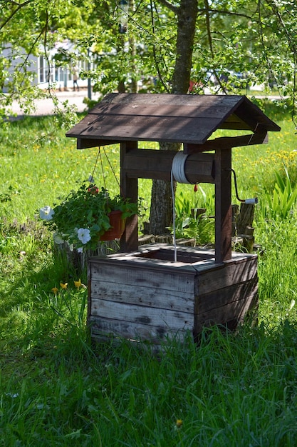 Foto pozo de madera decorativo en el jardín hierba verde día soleado