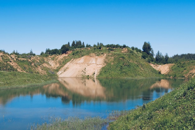 Üppiges Grün und malerische blaue Seen Sommerlandschaft für Outdoor-Urlaub Wandern Camping oder Tourismus Hill in der Mitte des Sees Wolokolamsk Bezirk der Region Moskau Sychevo Strand Russland