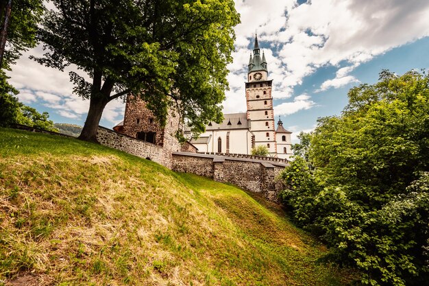 Praça da cidade histórica na cidade mineira Kremnica na Eslováquia As perspectivas para o castelo e a igreja de Santa Catarina na cidade