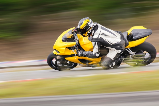 Foto práctica de motocicleta inclinándose en una curva rápida en la pista