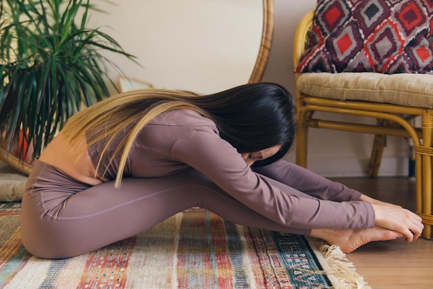 Práctica de yoga en casa mujer haciendo ejercicios de estiramiento concepto de estilo de vida saludable