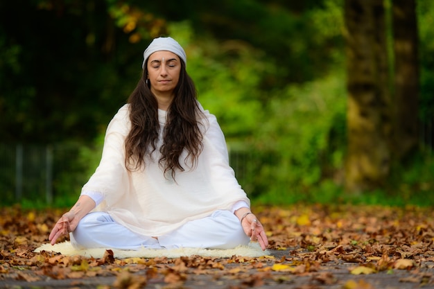 Práctica de yoga en el parque de otoño por una niña.