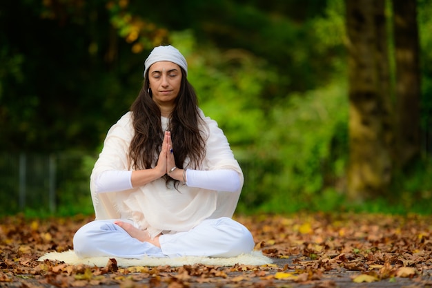 Práctica de yoga en el parque de otoño por una niña.