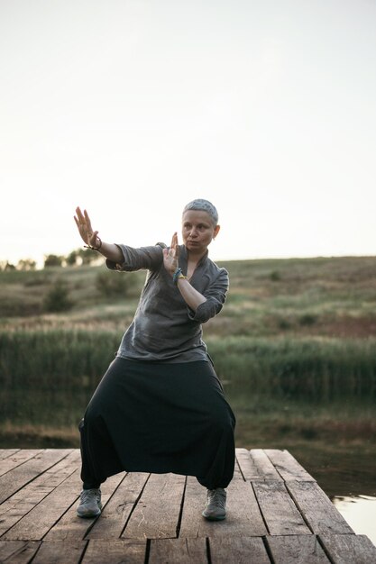 Foto practicando qigong ejercicio taichi mujer en la naturaleza