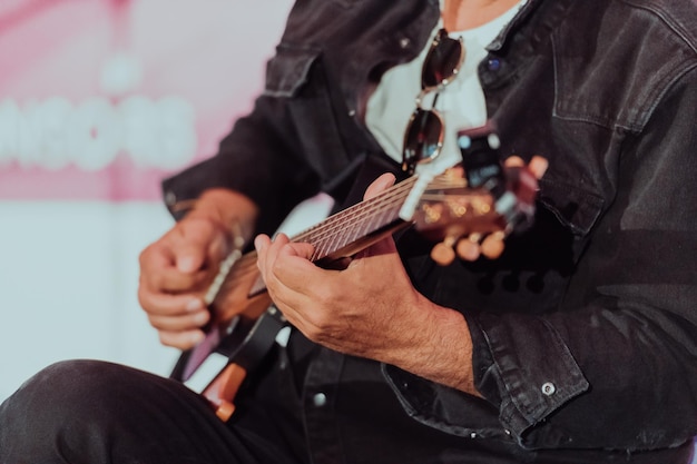 Practicando en tocar la guitarra. Apuestos jóvenes tocando la guitarra. foto de alta calidad