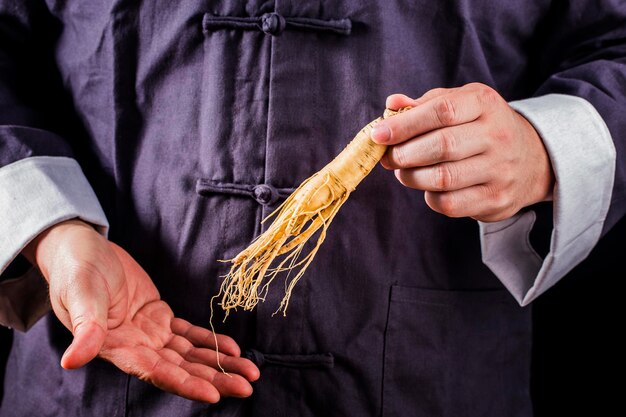 Un practicante de medicina china está seleccionando la medicina tradicional china de ginseng