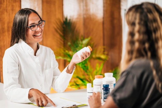 Practicante de medicina funcional recomendando un suplemento dietético a un cliente