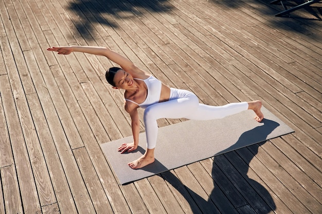 Practicante profesional de yoga Mujer joven con ropa de fitness está al aire libre