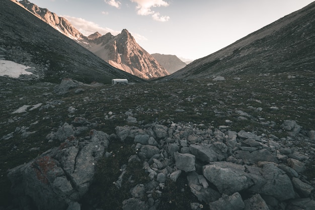 Praderas alpinas y pastos en medio de la cordillera de gran altitud en las puestas de sol. Los Alpes italianos, famoso destino turístico en verano. Imagen tonificada, filtro vintage, tonificación dividida.